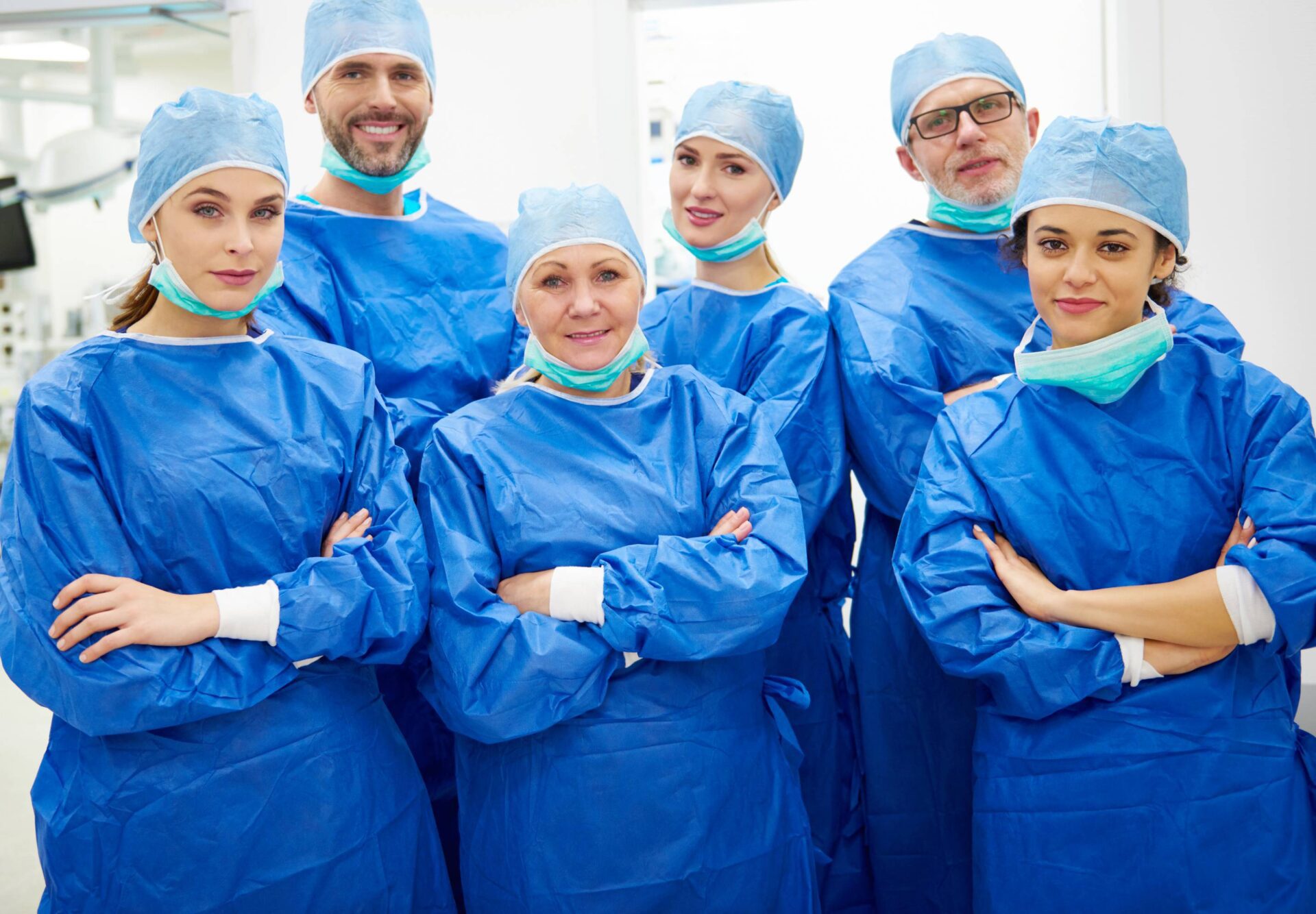 A diverse group of doctors wearing blue scrub suits, standing together in a professional setting